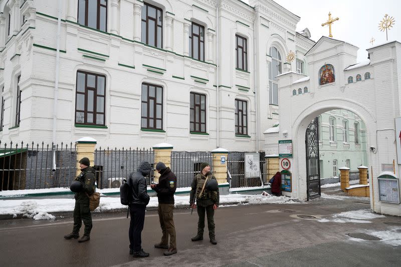 Ukrainian law enforcement officers check documents of a visitor of the Kyiv Pechersk Lavra monastery in Kyiv