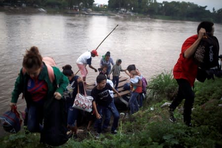 Central American migrants get off a raft after crossing the Suchiate river from Tecun Uman, in Guatemala, to Ciudad Hidalgo, as seen from Ciudad Hidalgo
