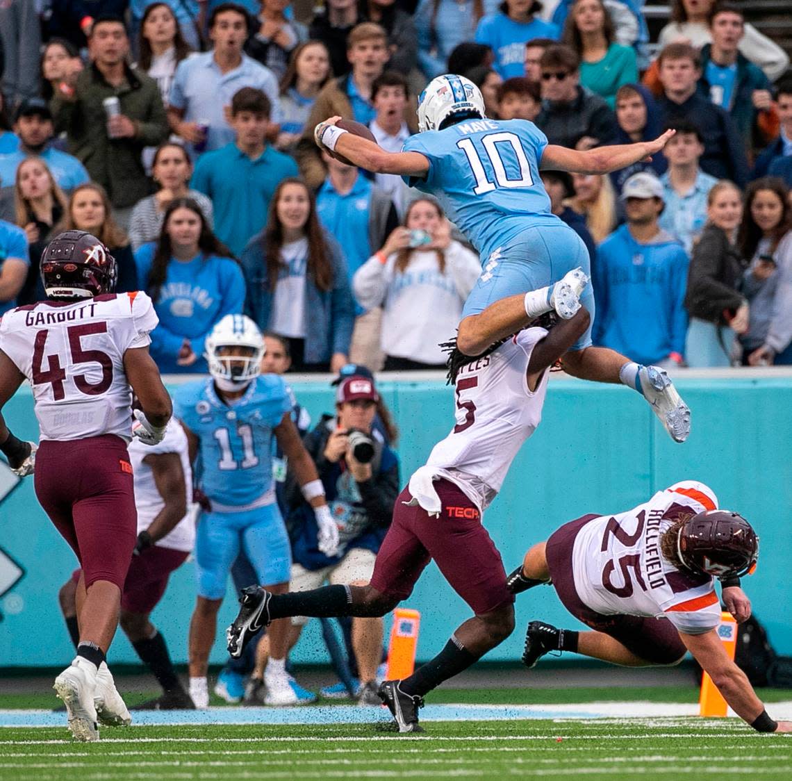 North Carolina quarterback Drake Maye (10) hurdles over Virginia Tech’s Nasir People (5) for a six-yard gain in the third quarter on Saturday, October 1, 2022 at Kenan Stadium in Chapel Hill, N.C. Maye was injured on the play.