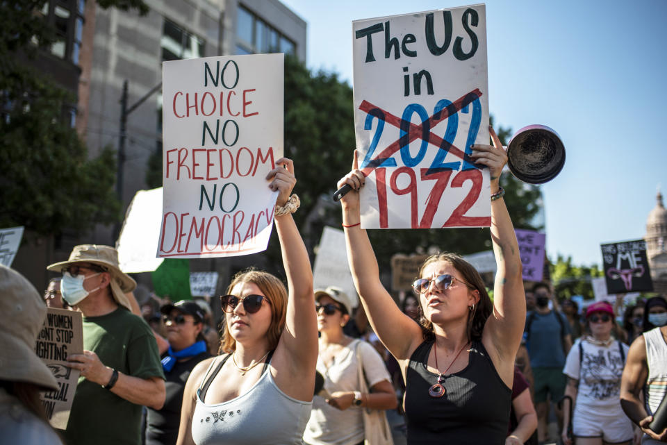 Demonstrators march while holding signs during an abortion-rights rally (Sergio Flores / Getty Images file)