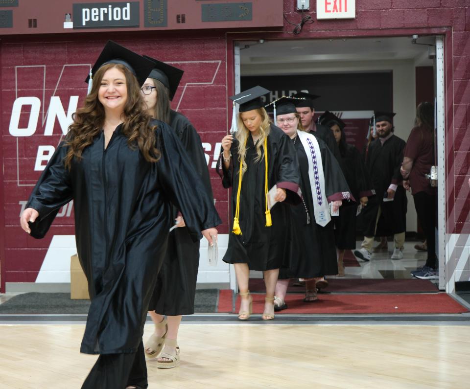 A graduate smiles as she walks onto the court Saturday at the WT Commencement Ceremony in Canyon.