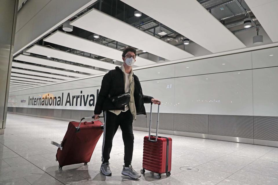 Passengers arrive at Heathrow Airport in London (PA)