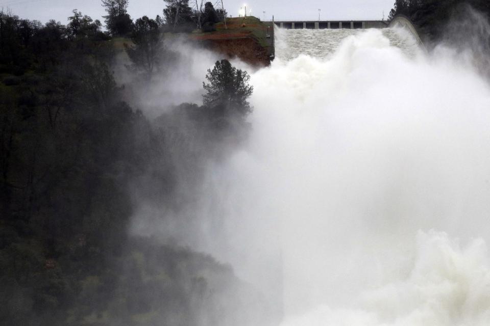 Water gushes down the Oroville Dam's main spillway Wednesday, Feb. 15, 2017, in Oroville, Calif. The Oroville Reservoir is continuing to drain Wednesday as state water officials scrambled to reduce the lake's level ahead of impending storms. (AP Photo/Marcio Jose Sanchez)