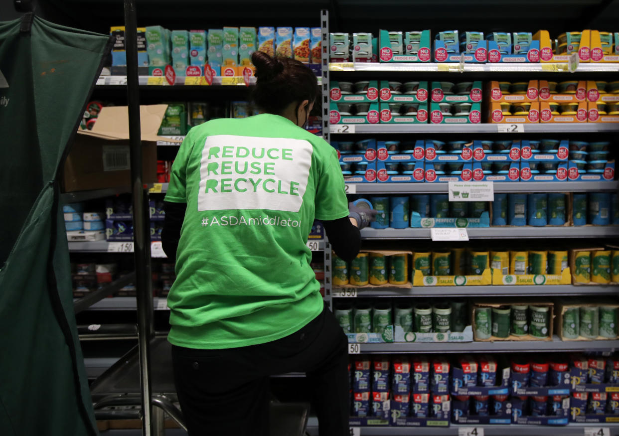 Asda A member of staff stacks loose tins on the shelves in the UK supermarket Asda, as the store launches a new sustainability strategy, in Leeds, Britain, October 19, 2020. Picture taken October 19, 2020. REUTERS/Molly Darlington