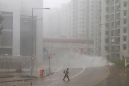 A man walks as high waves hit the shore at Heng Fa Chuen, a residental district near the waterfront, as Typhoon Mangkhut slams Hong Kong, China September 16, 2018. REUTERS/Bobby Yip