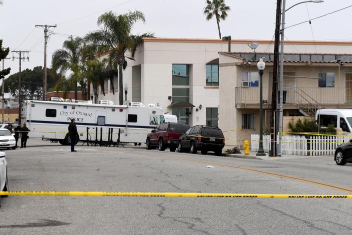 Oxnard police investigate a shooting by an officer at an apartment building on Seventh Street Friday. A man reportedly approached the officer holding a knife before he was shot, authorities said.