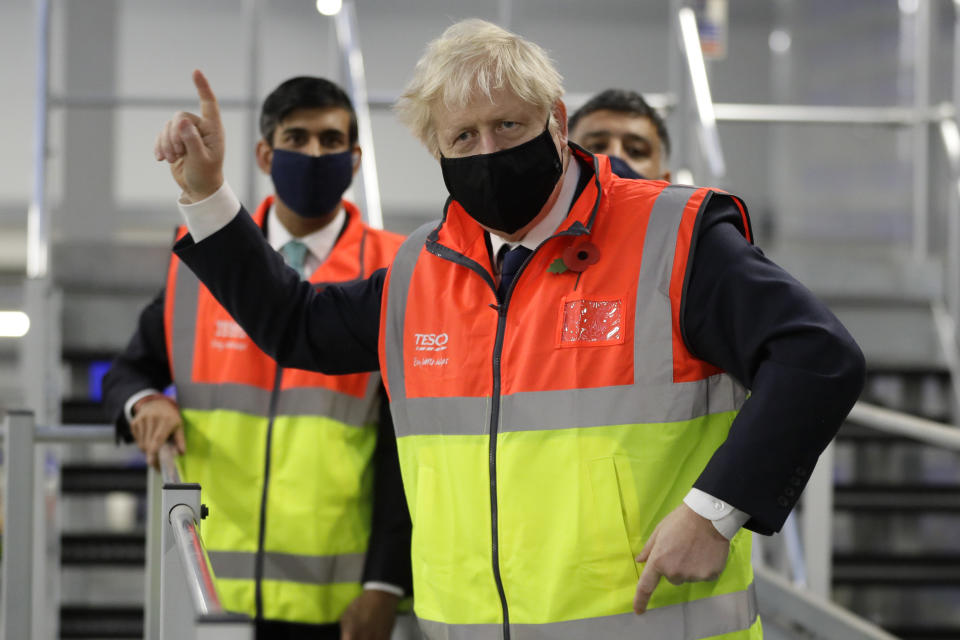 Britain's Prime Minister Boris Johnson, and Chancellor Rishi Sunak during a visit to a tesco.com distribution centre in London, Wednesday, Nov. 11, 2020. (AP Photo/Kirsty Wigglesworth, pool)
