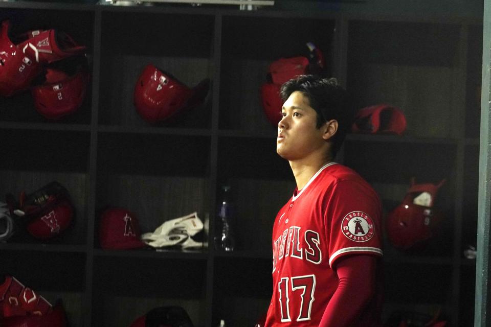 Los Angeles Angels Shohei Ohtani, of Japan, looks out from the dugout before batting in the fifth inning of a baseball game against the Texas Rangers in Arlington, Texas, Monday, May 16, 2022. (AP Photo/LM Otero)