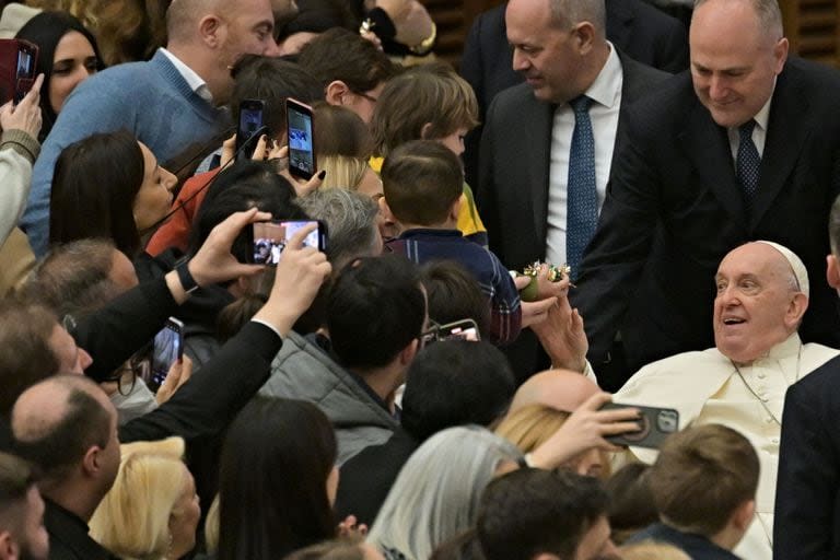 El papa Francisco da dulces a los niños durante la audiencia privada de saludos navideños de los empleados del Vaticano en el salón Pablo VI del Vaticano, el 21 de diciembre de 2023