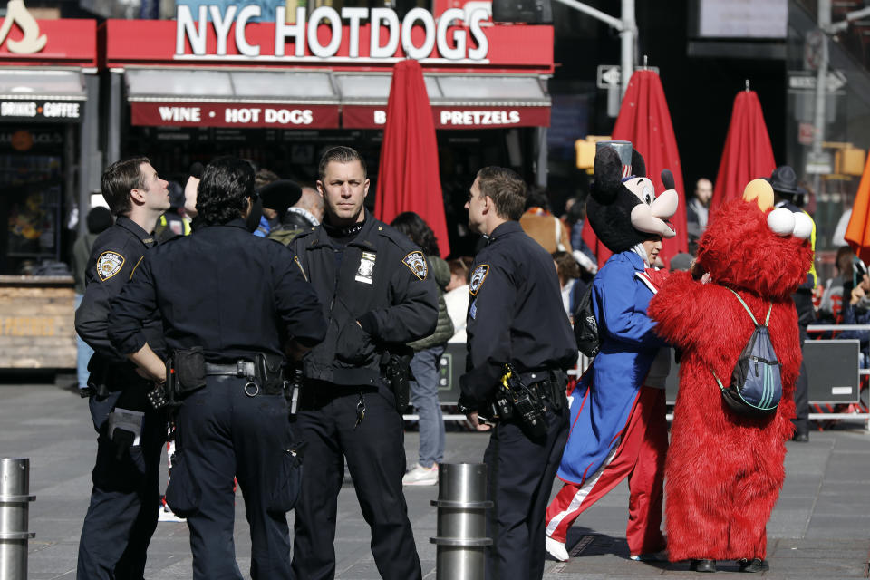 New York City Police Department officers confer in New York's Times Square, Friday, Oct. 19, 2018. New reforms aimed at improving police interactions in New York City include requirements that officers hand out their business cards to people they stop and explain why law enforcement activity is taking place. (AP Photo/Richard Drew)