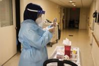 FILE - In this Jan. 15, 2021, file photo, a CVS Pharmacist prepares a COVID-19 vaccine for the nursing home residents at Harlem Center for Nursing and Rehabilitation, a nursing home facility in Harlem neighborhood of New York. (AP Photo/Yuki Iwamura, File)