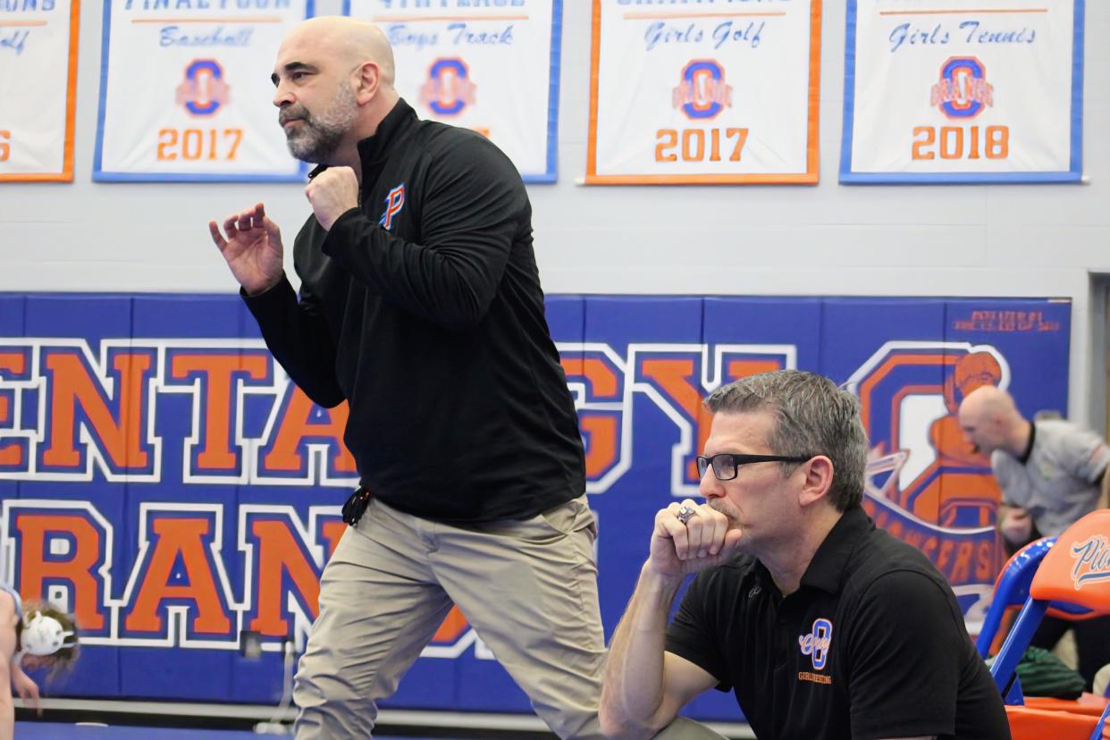 Olentangy Orange girls wrestling coach Brian Nicola, left, and assistant coach Dominic DiSabato watch the action during a match this season.