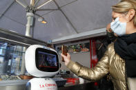 A machine checks a woman's vaccine pass, at a restaurant in Lille, northern France, Monday, Jan. 24, 2022. Unvaccinated people are no longer allowed in France's restaurants, bars, tourist sites and sports venues, as a new law came into effect Monday requiring a "vaccine pass" that is central to the government's anti-virus strategy. (AP Photo/Michel Spingler)