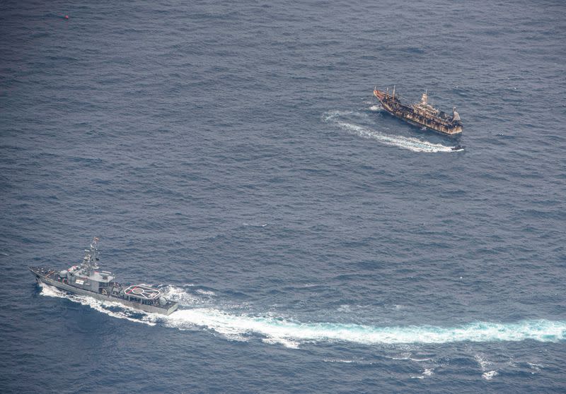 Ecuadorian Navy vessels surround a fishing boat after detecting a fishing fleet of mostly Chinese-flagged ships in the Pacific Ocean