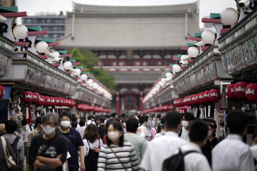 Visitors walk along a shopping street at the Asakusa district Friday, June 10, 2022, in Tokyo. Japan on Friday eased its borders for foreign tourists and began accepting applications, but only for those on guided package tours who are willing to follow mask-wearing and other antivirus measures as the country cautiously tries to balance business and infection worries. (AP Photo/Eugene Hoshiko)