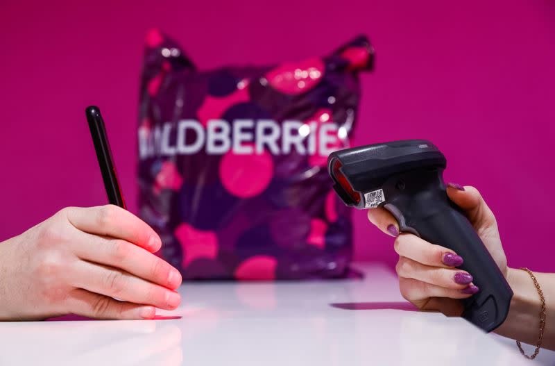 Employee of Wildberries online retailer scans a code on a screen of a smartphone at a pickup point in Moscow