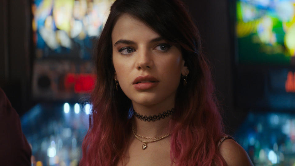 Sonia Ammar stands in front of pinball machines with a suspicious look in Scream (2022).