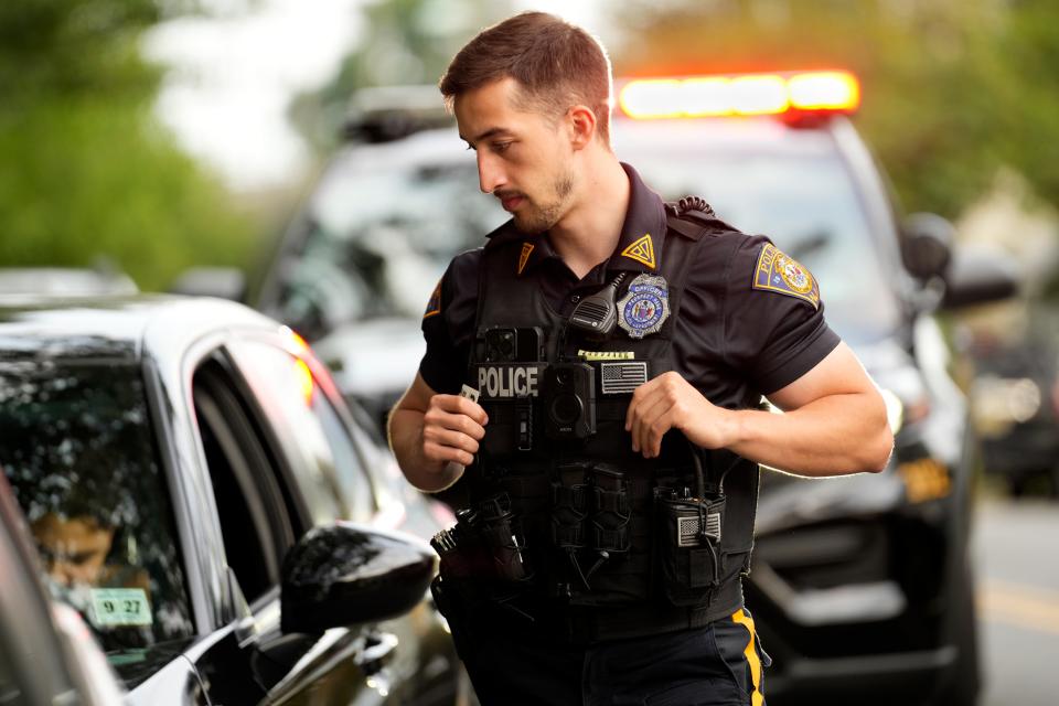 Prospect Park Police Officer Alan Kozrosh looks over a driver's vehicle after making a traffic stop. Thursday, August 3, 2023