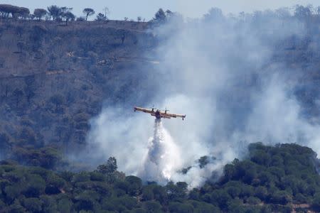 A Canadair firefighting plane drops water to extinguish a forest fire on La Croix-Valmer from Cavalaire-sur-Mer, near Saint-Tropez, France, July 25, 2017. REUTERS/Jean-Paul Pelissier