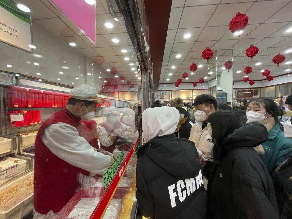 Workers pack new year gift boxes for waiting customers at a branch of Daoxiangcun, one of the best-known Chinese bakeries in Beijing, China, on Jan. 14, 2023. (AP Photo/Caroline Chen)