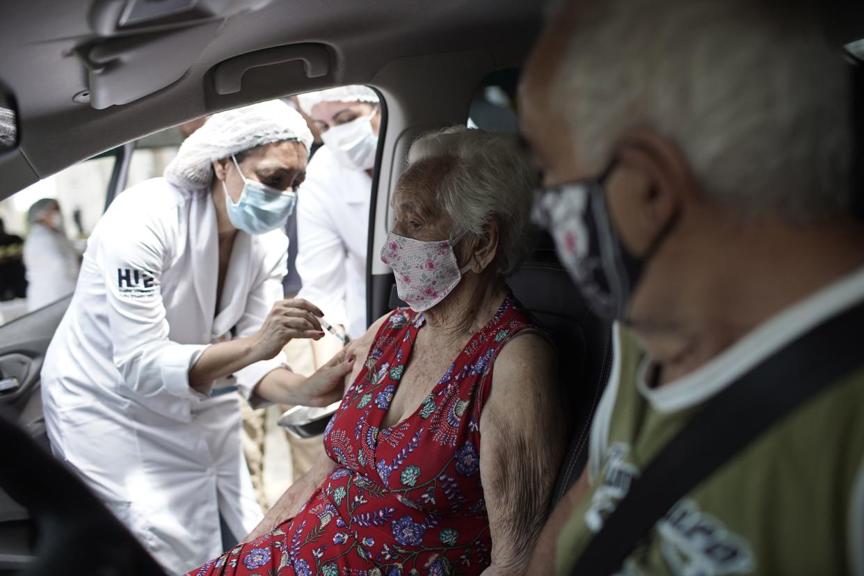 An elderly woman gets a shot of China's Sinovac CoronaVac vaccine as part of a priority COVID-19 vaccination program for the elderly at a drive-thru vaccination center in Rio de Janeiro, Brazil, Monday, Feb. 1, 2021.