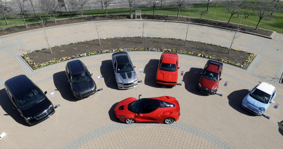 A LaFerrari, center, is displayed alongside Fiat and Chrysler vehicles at Chrysler Group LLC world headquarters in Auburn Hills, Mich., Tuesday, May 6, 2014. Fiat Chrysler Automobiles NV unveiled its business strategy for the next five years to investors as it prepares for life as a newly merged company. (AP Photo/Carlos Osorio)