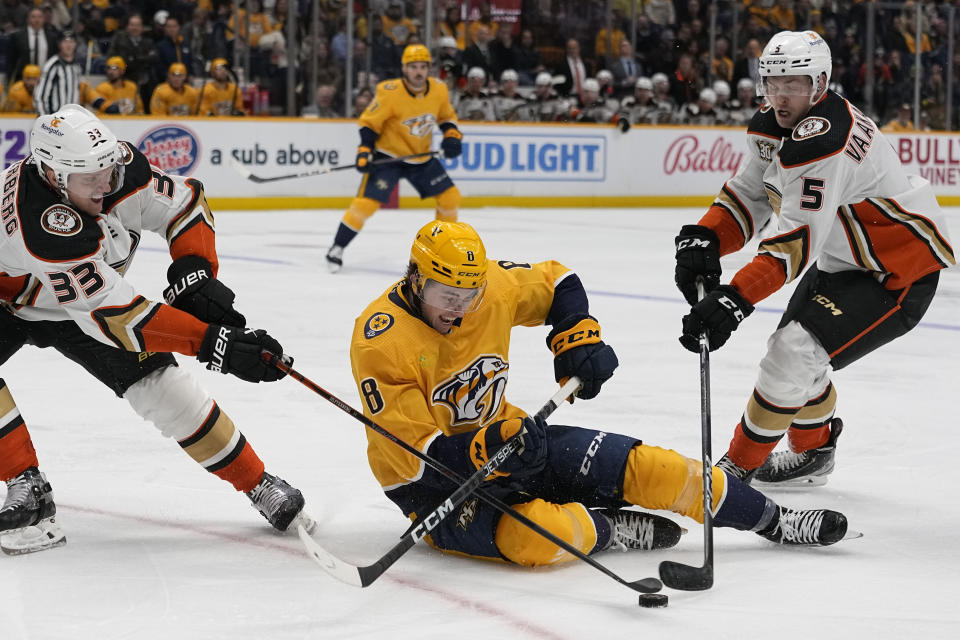 Nashville Predators center Cody Glass (8) battles Anaheim Ducks right wing Jakob Silfverberg (33) and defenseman Urho Vaakanainen (5) for the puck during the second period of an NHL hockey game Tuesday, Nov. 14, 2023, in Nashville, Tenn. (AP Photo/George Walker IV)