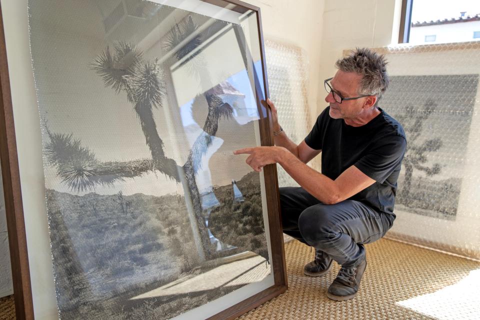 Argentine artist Marcelo Bengoechea points out the weaves on his late brother Fernando Bengoechea's original artwork before displaying it inside Super Simple in Palm Springs, Calif., on Wednesday, Feb. 15, 2023. Bengoechea's late brother, Fernando Bengoechea, pioneered the woven photography technique of weaving two identical prints to create one image. Marcelo has made it his mission to keep his brother's art alive by creating similar art.