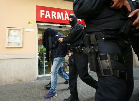 Spanish police lead a suspect from an apartment building during a sweeping operation at some 12 locations against Islamist militants in which eight people were arrested in Barcelona, Spain, April 25, 2017. REUTERS/Albert Gea