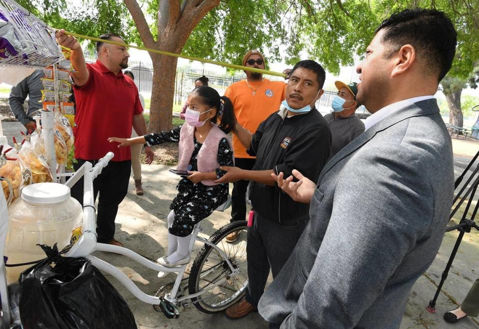 Fresno City Councilmember Luis Chavez, right, talks with street food vendor Miguel Lopez during the launch of the security camera pilot program for Fresno street food vendors in March 2022.