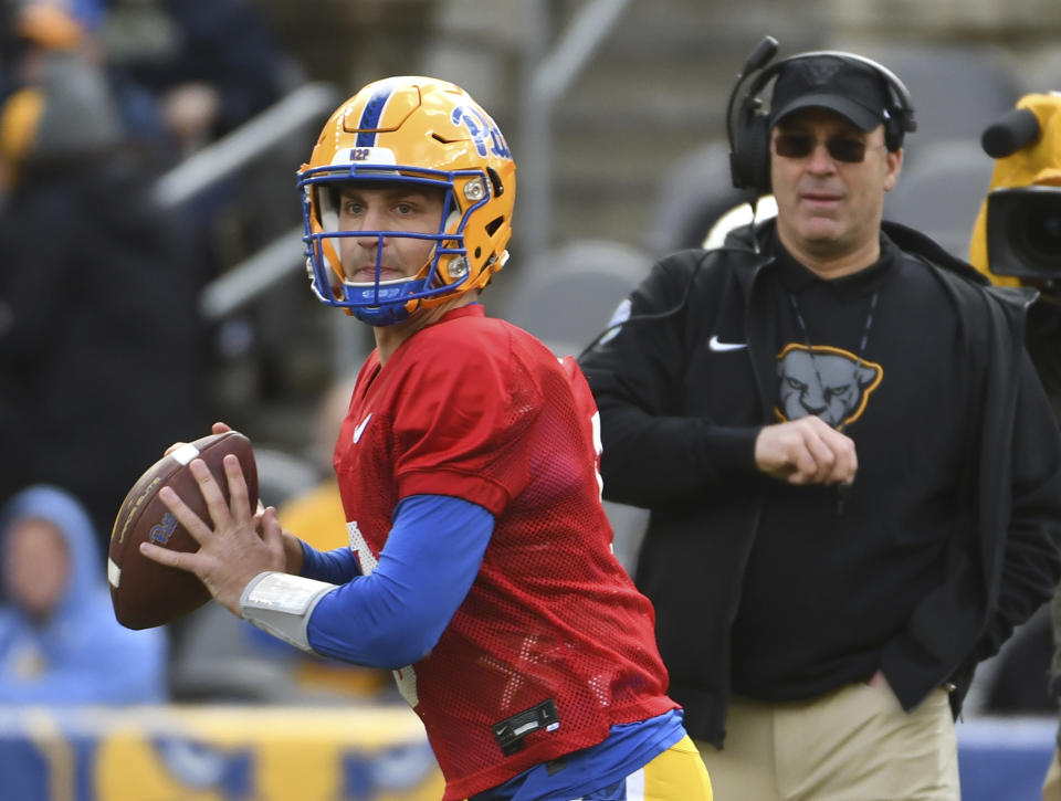 FILE - Pittsburgh quarterback Kedon Slovis (9) scrambles as head coach Pat Narduzzi, right, looks on during their annual NCAA college football intrasquad Blue-Gold scrimmage in Pittsburgh, April 9, 2022. USC transfer Kedon Slovis will start for No. 17 Pittsburgh when the Panthers open the season against West Virginia on Sept. 1.(AP Photo/Philip G. Pavely, File)
