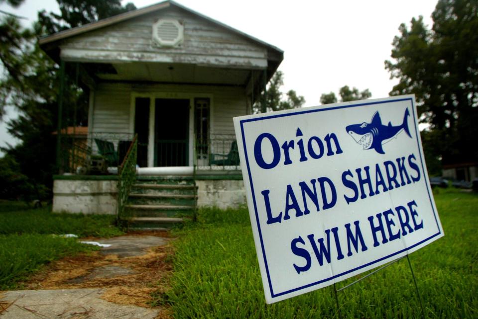 A sign posted in the lawn of New Sarpy resident Don Wonston protests the Orion refinery which can be seen from Winston's front porch. While activist Winston cites health concerns for residents living near the refinery that's located in an area known as "canceralley", Louisiana Senator John Breaux has pushed the EPA to give Orion special treatment by relaxing their pollution standards as the refinery starts up. The son of Senator Breaux, John Breaux Jr. reporesents Orion.