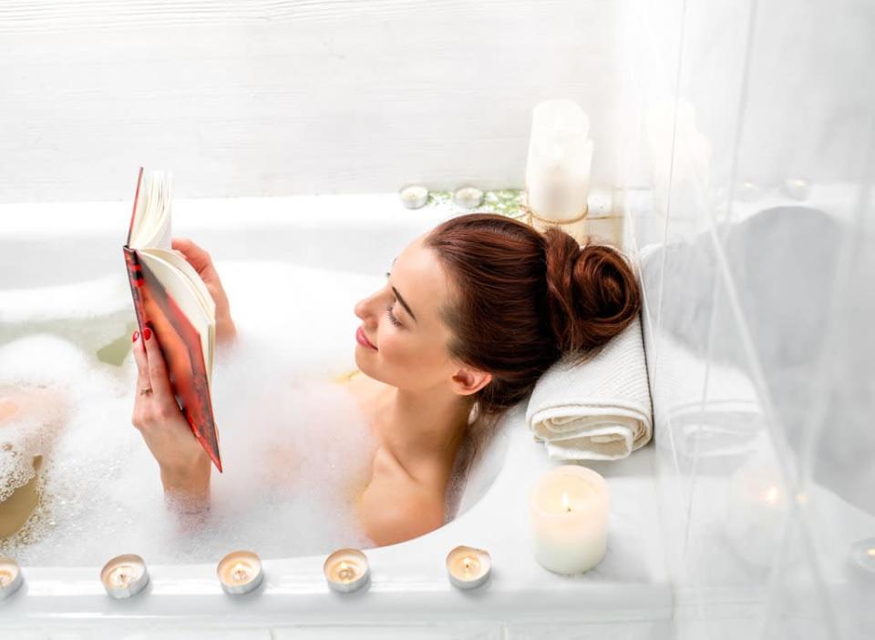 Woman reading in a bath