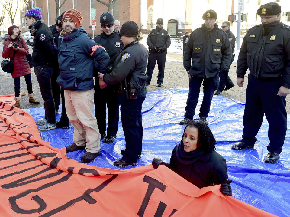 John Lugo, of Unidad Latina en Accion of New Haven, is arrested during a demonstration after some protesters blocked the intersection of Elm and College Streets in New Haven, Conn., Friday, Feb. 10, 2017, and refused to move. The protesters are in favor of changing the name of Yale University's Calhoun College. The peaceful arrests were pre-planned and coordinated between the demonstrators and New Haven Police. (Peter Hvizdak/New Haven Register via AP)