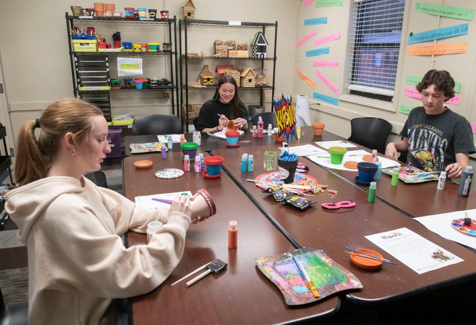 Chain Reaction volunteer students Ellie Speck, My-Lan Eberhard, and Anderson Tanner work on a crafts project during a team meeting on Friday, Feb. 9, 2024.