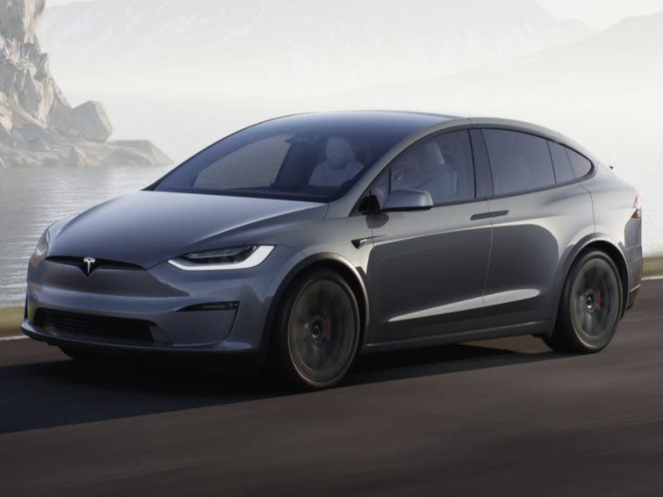 A gray Tesla Model X SUV drives down a road.