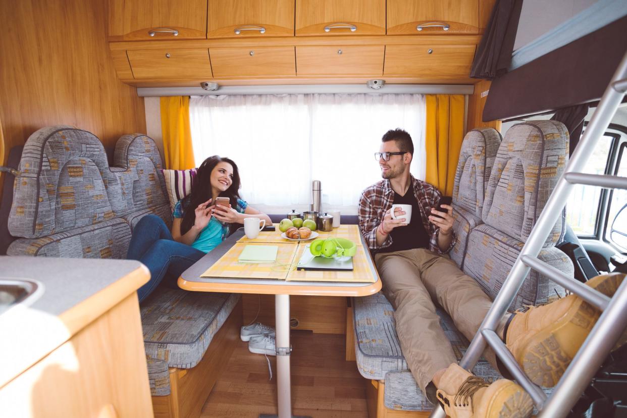 Young couple enjoying breakfast in camper van