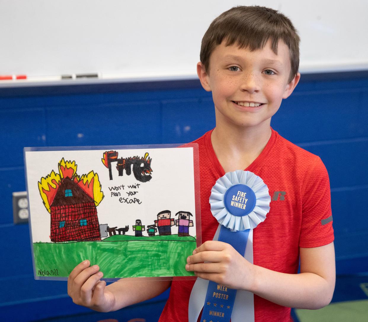 Nolan Ratliff, a third grader at Tuslaw Elementary School, shows off his winning poster. Ratliff's creation about fire safety garnered first place in the Ohio State Fire Marshal's fire safety poster contest.