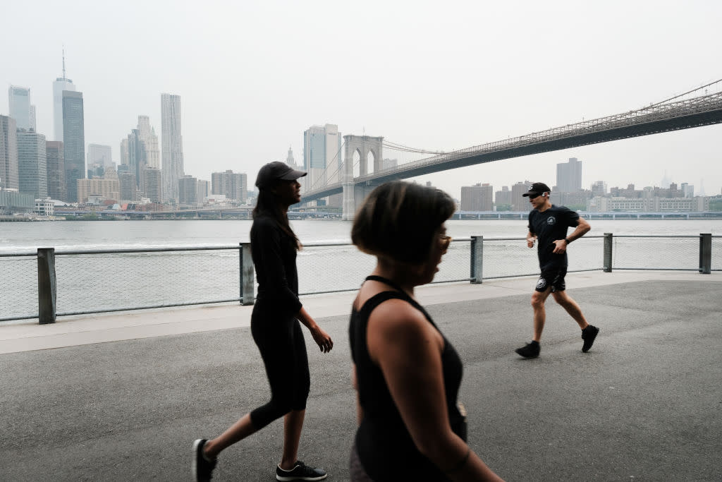 People walk through a Brooklyn Park on a hazy morning resulting from Canadian wildfires on June 6, 2023 in New York City. Over 100 wildfires are burning in the Canadian province of Nova Scotia and Quebec causing air quality health alerts for New York State and parts of New England.