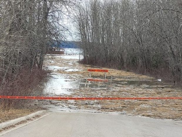 A road closed sign and caution tape blocking a flooded road in Fort Simpson. Tim Tomezynski, Tulita's Fire Chief described the floods as horrific: 'Since my time here, this has been the worst that I have heard of.'