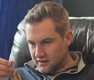 Man sitting, opening Easter basket, with text overlay about brother's age and marital status