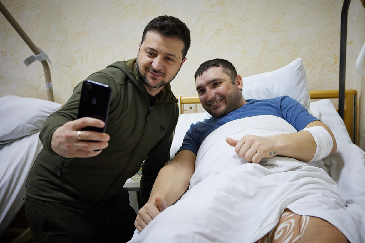 In this photo provided by the Ukrainian Presidential Press Office on Sunday, March 13, 2022, President Volodymyr Zelenskyy, left, takes a picture with a wounded soldier during his visit to a hospital in Kyiv, Ukraine. (Ukrainian Presidential Press Office via AP)