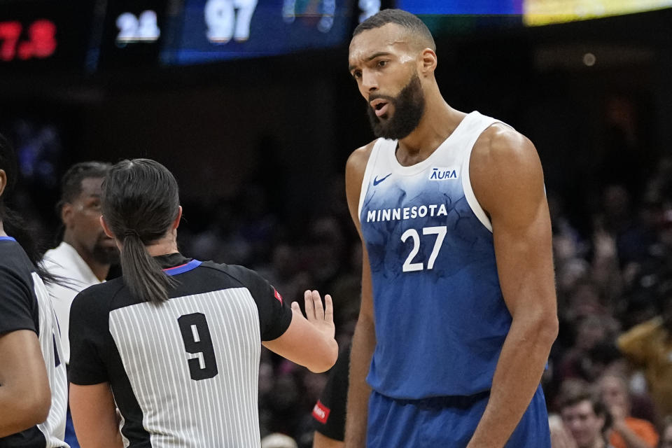 Minnesota Timberwolves center Rudy Gobert (27) talks with referee Natalie Sago (9) after being called for a technical foul in the second half of an NBA basketball game against the Cleveland Cavaliers, Friday, March 8, 2024, in Cleveland. (AP Photo/Sue Ogrocki)