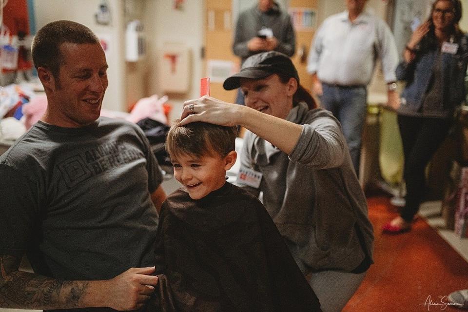 Madi's father, Chris, and her brother sit down for haircuts to show support after acute myeloid leukemia treatment caused her to lose her hair. (Photo: Alicia Samone Photography)