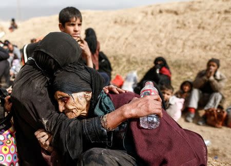 Khatla Ali Abdullah, 90, is embraced as she flees her home as Iraqi forces battle with Islamic State militants in western Mosul, Iraq February 27, 2017. REUTERS/Zohra Bensemra