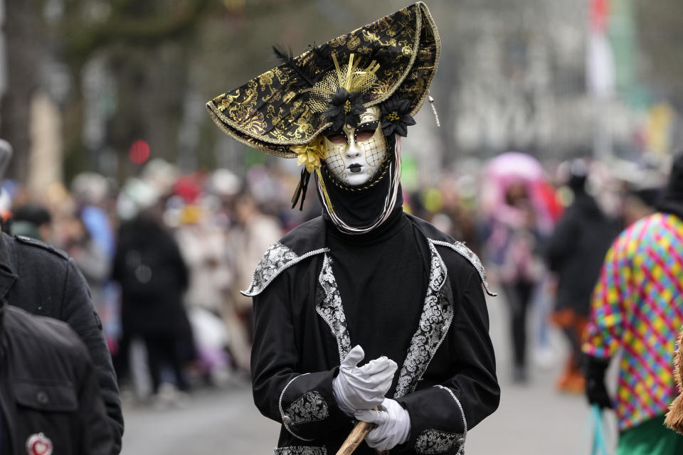A dressed reveller walks a street ahead of the traditional carnival parade in Duesseldorf, Germany, on Monday, Feb. 20, 2023. The foolish street spectacles in the carnival centers of Duesseldorf, Mainz and Cologne, watched by hundreds of thousands of people, are the highlights in Germany's carnival season on Rosemonday. (AP Photo/Martin Meissner)