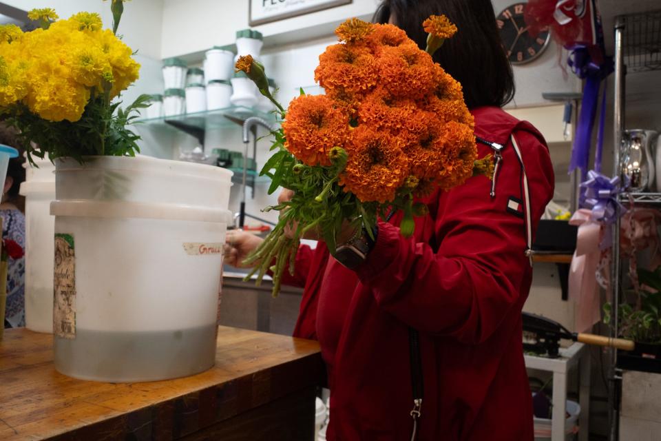 Leticía Domínguez Murillo helps prepare cempasúchil arrangements as soon as they arrive at Yosi's Flower Shop in Tucson.