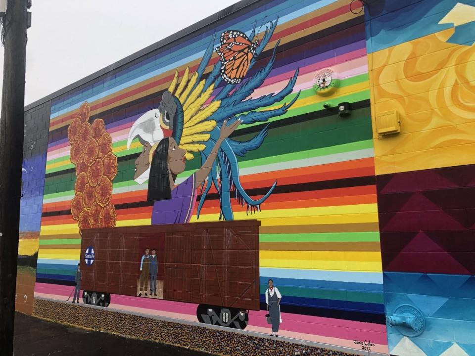 This mural, painted by Jaime Colón, celebrates the migration of Latino Americans to Topeka. The mural is on the east side of the Habitat for Humanity ReStore.