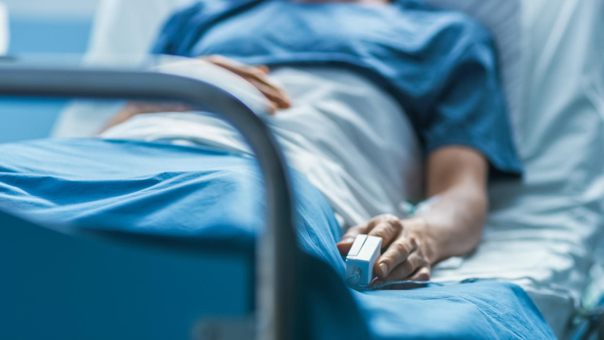 A patient lies in a hospital bed.