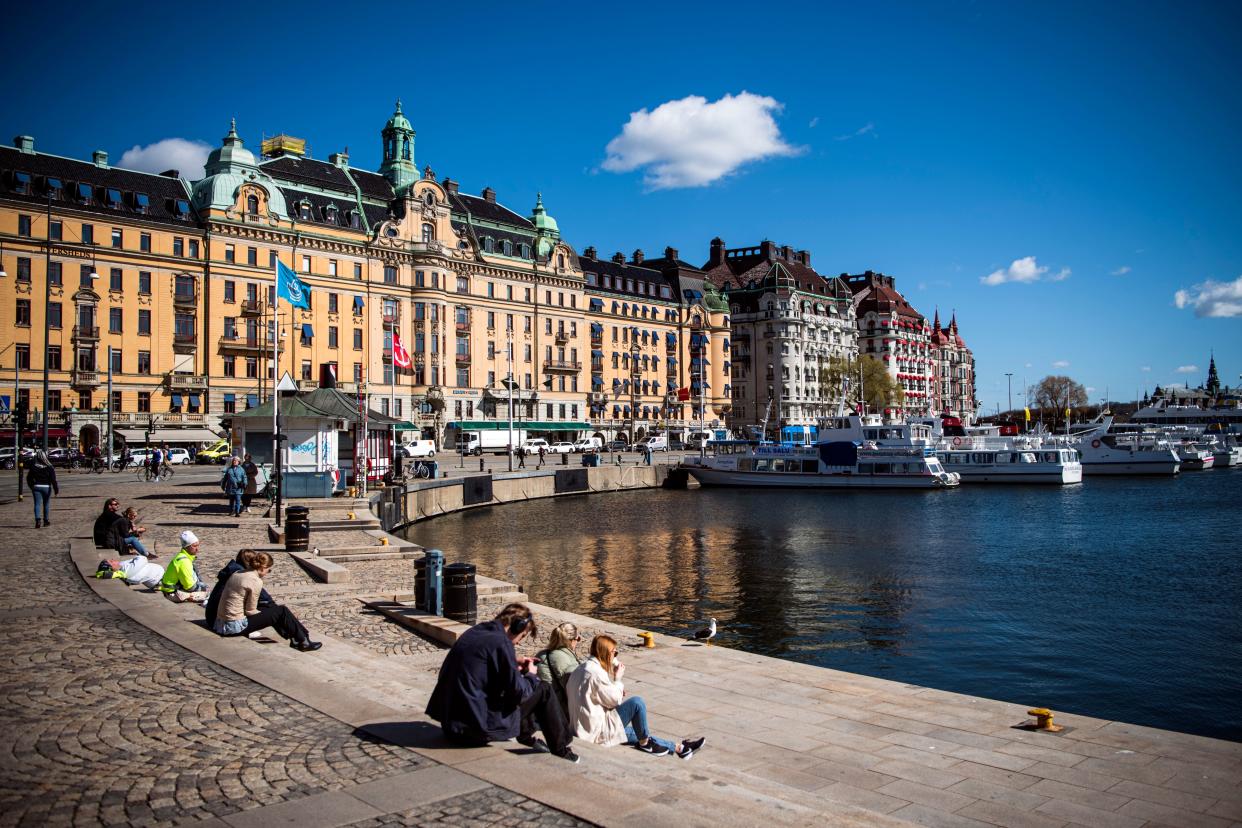 People enjoy the spring weather as they sit at Nybroplan in Stockholm on April 15, 2020, during the coronavirus COVID-19 pandemic. (Photo by Jonathan NACKSTRAND / AFP) (Photo by JONATHAN NACKSTRAND/AFP via Getty Images)